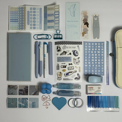 Blue stationery planner set flat lay with journal, pens and stickers