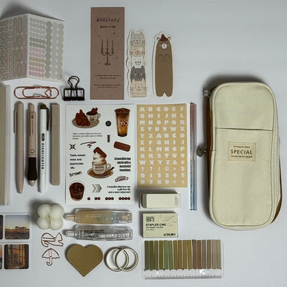 Brown stationery planner set flat lay with journal, pens and stickers