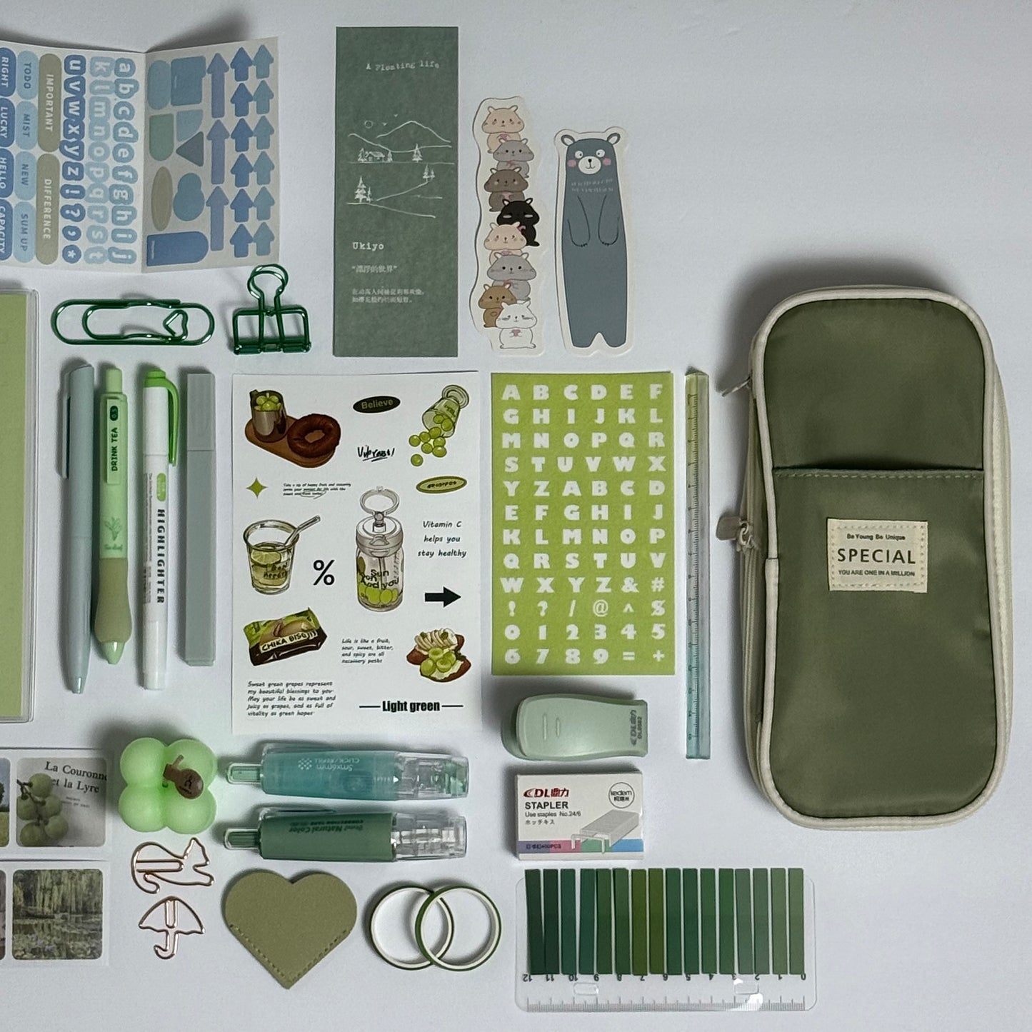 Green stationery planner set flat lay with journal, pens and stickers
