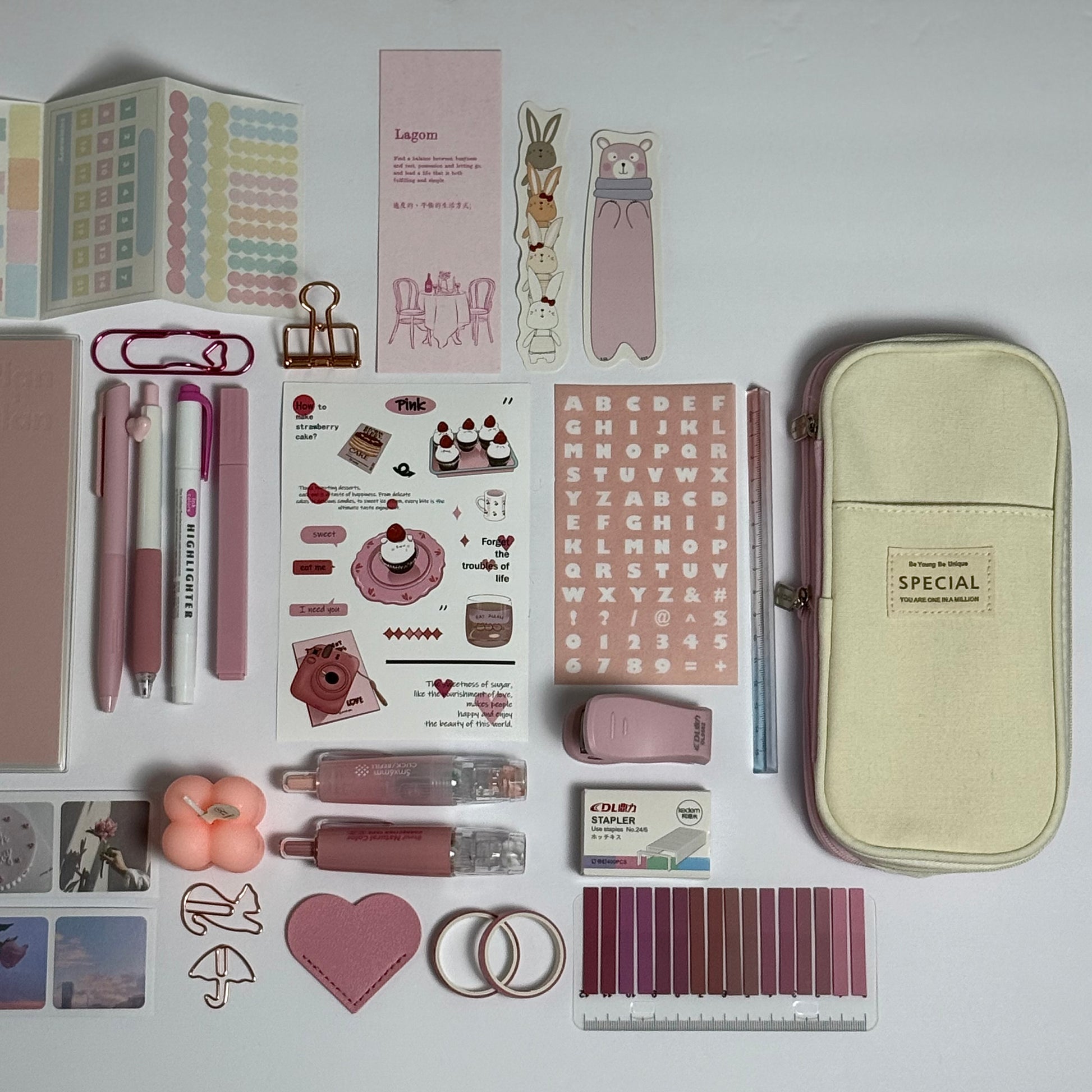 Pink stationery planner set flat lay with journal, pens and stickers