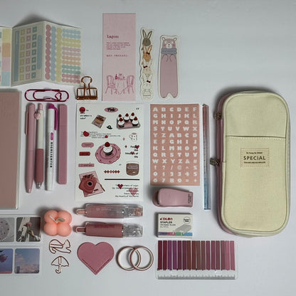 Pink stationery planner set flat lay with journal, pens and stickers
